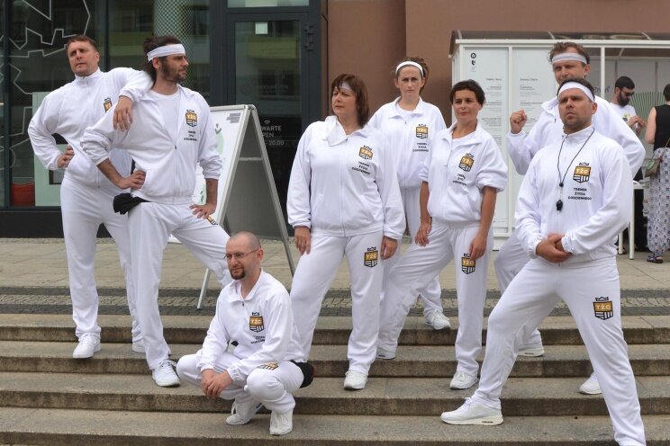 Trenerzy pozują do zdjęcia grupowego ustawieni na schodach